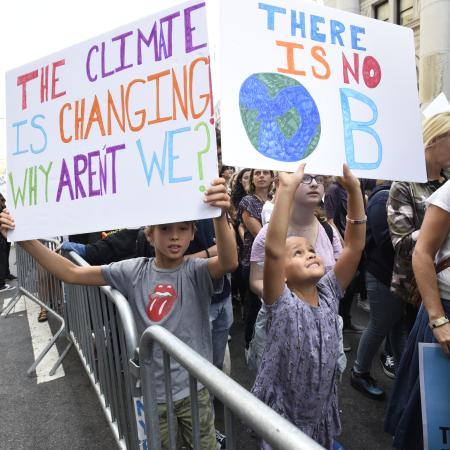 Young people at a climate protest holding placards on climate change.