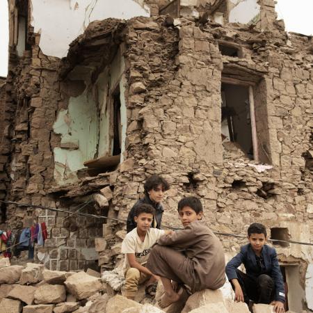 Boys sit in front of a bombed house in Sana'a Yemen