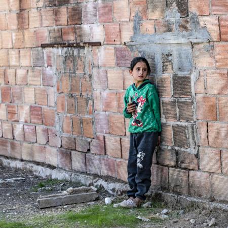 A child stands outside the ruins of a building in rural Syria.