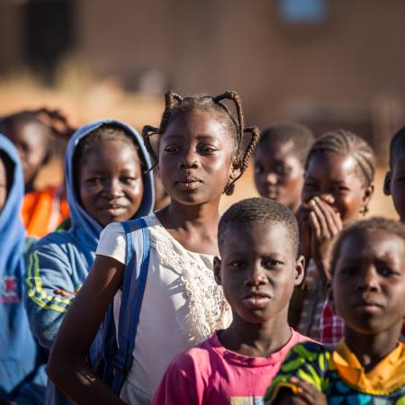 On 3 December 2019, [NAME CHANGED] Nabyla (centre), 13, waits to enter school with her classmates in Kaya, Burkina Faso, the town in which her family found refuge after being displaced. 