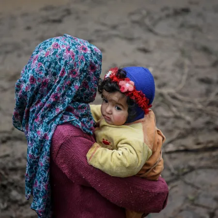 A girl carries a baby in northwest Syria.