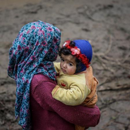 A girl carries a baby in northwest Syria.
