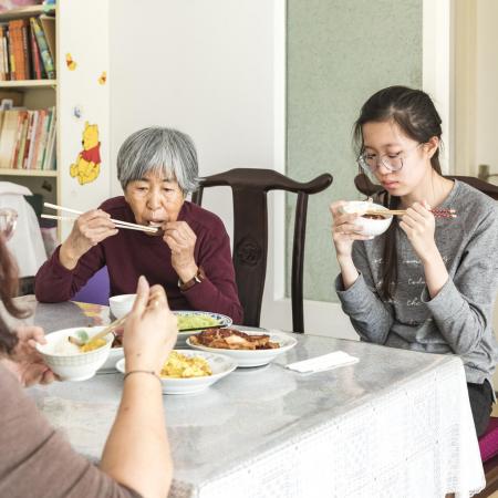 A girl in Beijing eats lunch with her family.