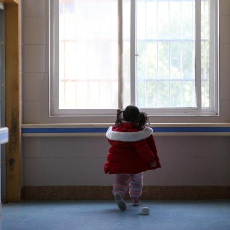 A little girl stands in a hospital ward in Wuhan, China.