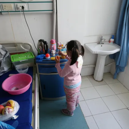 Yuanyuan washes her hands in the hospital ward where she is currently under isolation.