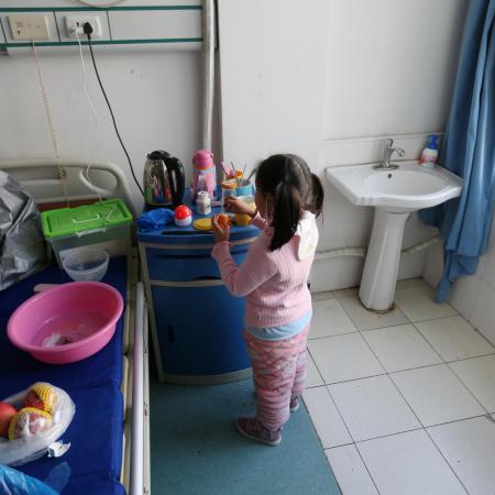 Yuanyuan washes her hands in the hospital ward where she is currently under isolation.