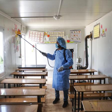 A Syrian volunteer disinfects a classroom in rural Idlib.