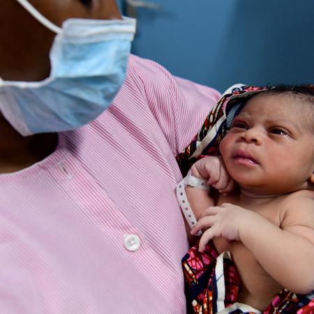 A nurse gives the first care, with a mouth mask, to a newborn in the health center of Port Bouet, a suburban f Abidjan, in the South of Côte d'Ivoire