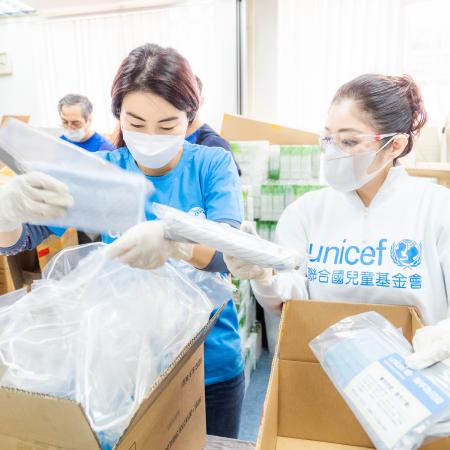 UNICEF workers unpacking with face masks on