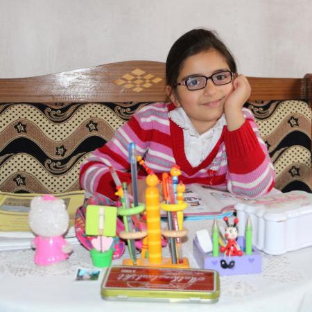 Masa, age 9, studies at her home in Syria.