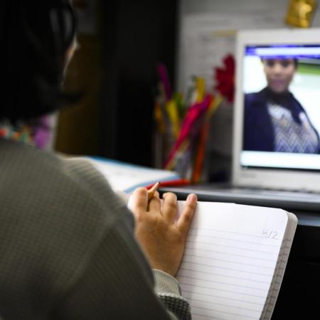 A student watches an lecture through their computer.