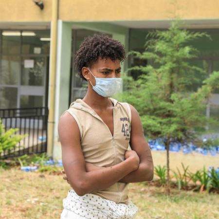 A young man stands outside a shelter for trafficked youth.