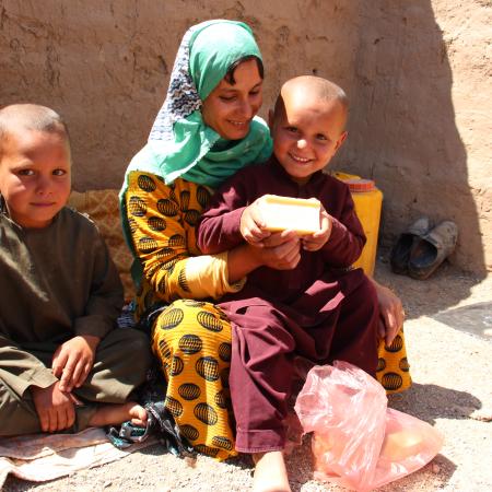 The picture shows a family who has received soap distribution in Herat IDP sites