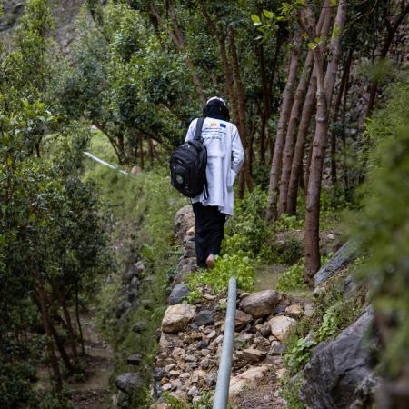 Saba walks up a stone path.