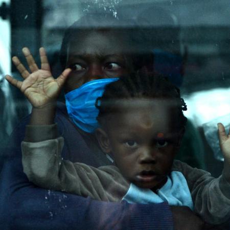 A mother and child are seen onboard a bus as they wait to be taken into quarantine.