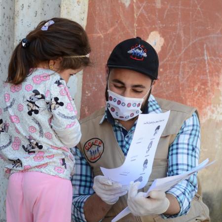 A UNICEF volunteer meets with a child in Syria.