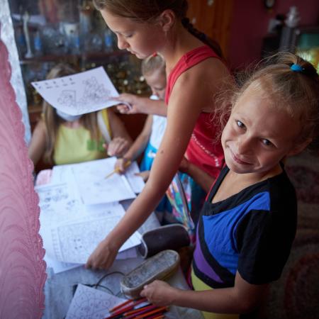 On 6 August 2020, sisters receive educational materials, including colouring books and exercise books, during a visit of a social worker and psychologist to their home in in Bilokurakyne, Eastern Ukraine.