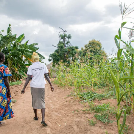 Harriet, a member of the Kilameling Parenting Without Violence group and chats with a para social worker from Save the Children in Kilameling ward, Obongi Town Council, Obongi District.