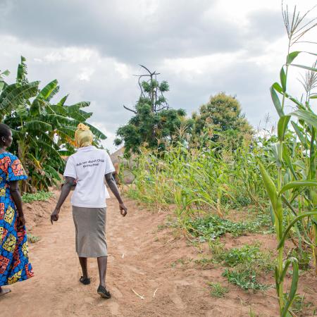 Harriet, a member of the Kilameling Parenting Without Violence group and chats with a para social worker from Save the Children in Kilameling ward, Obongi Town Council, Obongi District.