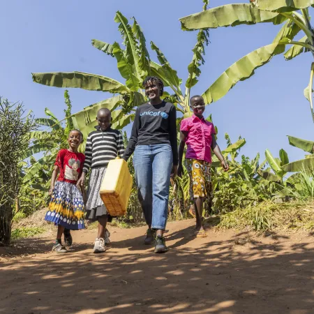 On 17 July 2023, UNICEF Goodwill Ambasador Vanessa Nakate walks with Adele (in pink), Graciella (in black and white stripes) and Bonette in Kigarama Sector, Kirehe District, Eastern Province of Rwanda.