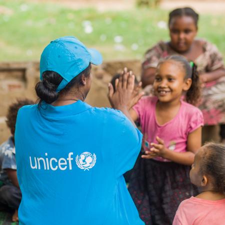 A UNICEF Staff member plays with a child in Sudan. 
