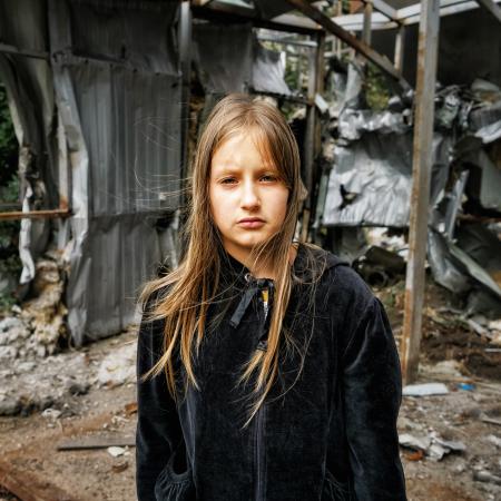 Arina, 10, stands on the spot where a shop used to be – right next to the children's playground in the village of Mala Rohan, in the Kharkiv region. Now it is a pile of rubble.