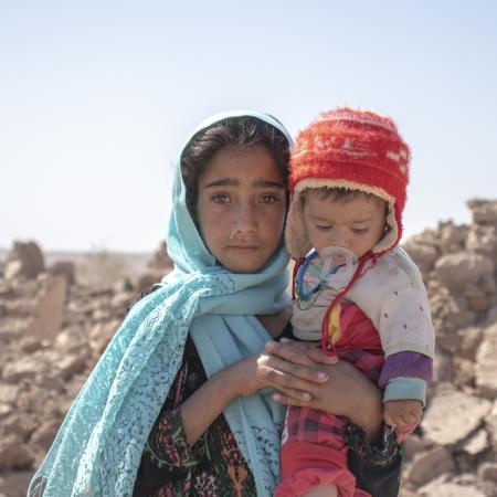 On 10 October 2023, 10-year-old Zari holds her brother Marv, 8 months old, in front of their collapsed house. They lost their home in the earthquake in Zinda Jan district in Herat Province, Afghanistan, which struck on 7 October.