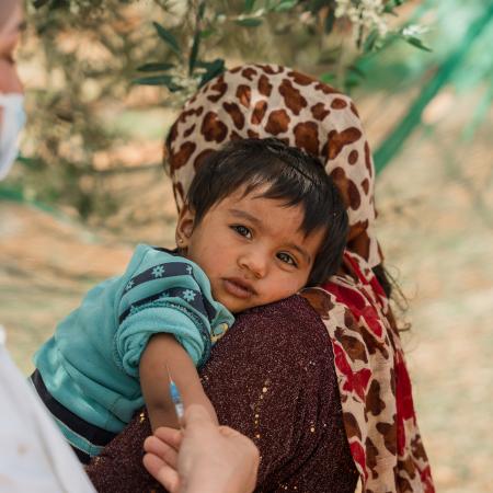 A child looks on as it is  vaccinated in the informal tented settlement in Jarish, north Jordan through UNICEF-supported immunization drive. 