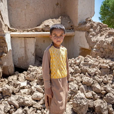 On the 28th May 2024, 9 year old Farzan is photographed in the ruins of his house in Chaghcharan district, Ghor province in western Afghanistan.