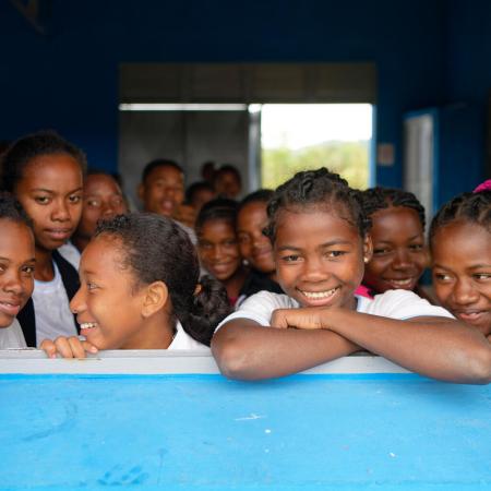 Mavorano Secondary School, Manakara District, Fitovinany Region, Madagascar (03/07/2024) : group photo of smiling schoolkids looking through the open window of their classroom taken during the visit of the school.