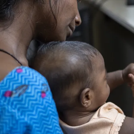 Mother living with HIV holds her baby at a testing centre