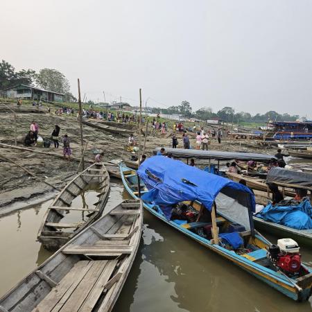 De petits bateaux de pêche semblent être échoués sur un rivage alors que les eaux de la crue se retirent.
