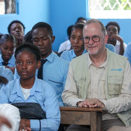 UNICEF Deputy Executive Director Ted Chaiban sits in a classroom with students in a school in Port-au-Prince, Haiti.