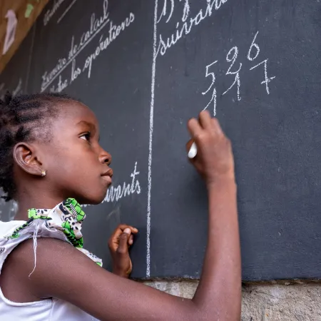 Une fille écrit sur un tableau dans un espace d’apprentissage temporaire (TLS) à Fada N'Gourma, dans la région de l’Est, au Burkina Faso.