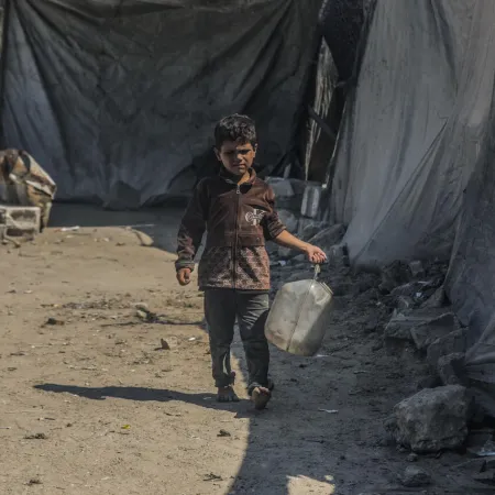 A boy carries a jerrycan of water in Gaza.