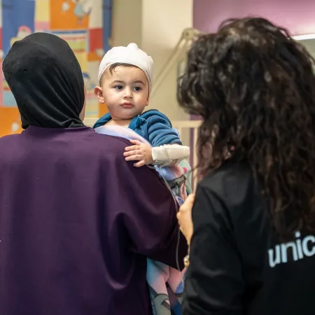 Child being held by his mother at a hospital in Beirut.