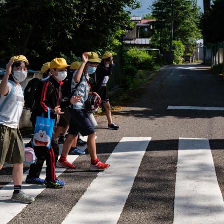 Children head to school in Japan, wearing masks to protect against COVID-19.