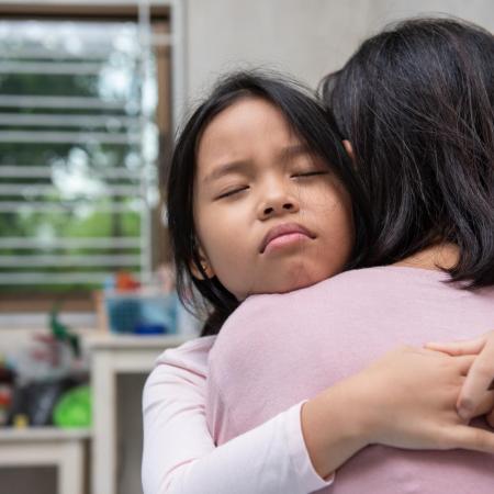 A girl hugs her mother.