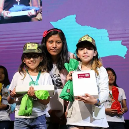 Girls receive awards at a tech event in Bolivia.