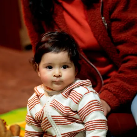 Une mère et son enfant assis par terre regardent un livre d’images.