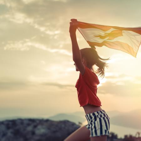 Young person running while holding Canadian flag