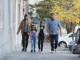 A migrant family walks down a street in Uruguay.