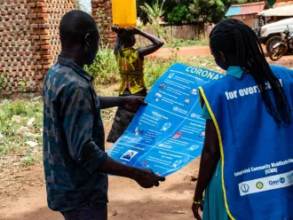 Community staffers inspect a COVID-19 education poster.