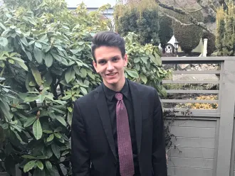 A photo of Augustin in a suit in his backyard, author of the blog