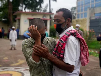 A man consoles his son who was just released from a youth detention centre for migrants.