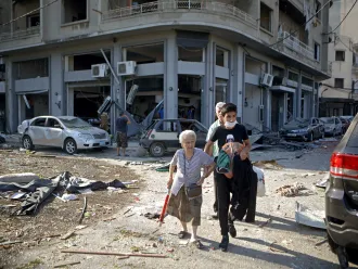 A woman is evacuated from the partially destroyed Beirut neighbourhood of Mar Mikhael on August 5, 2020 in the aftermath of a massive explosion in the Lebanese capital. - Rescuers searched for survivors in Beirut today after a cataclysmic explosion at the port sowed devastation across entire neighbourhoods, killing more than 100 people, wounding thousands and plunging Lebanon deeper into crisis.