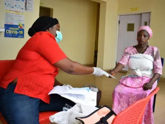 A registrar shows a new mother a birth registration form.