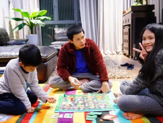 A family plays a board game at home together in Vietnam.