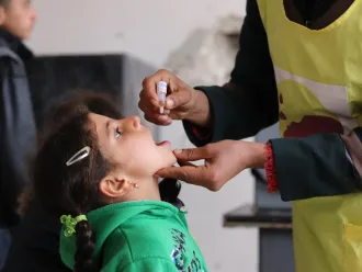 Lors d’une campagne de vaccination à Alep, en Syrie, une travailleuse de la santé de l’UNICEF donne à une jeune fille une dose de vaccin antipoliomyélitique oral.