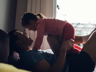 Father playfully lifting his daughter in the air